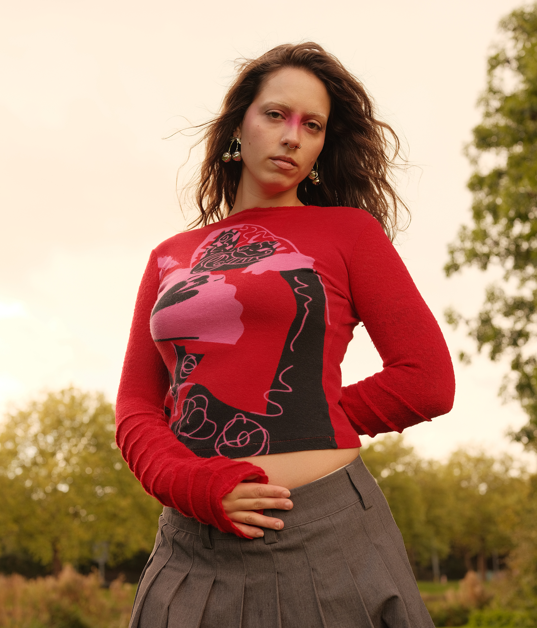 Een portret van een dame met uitgesproken make-up, we zien haar geposeerd in de buitenlucht