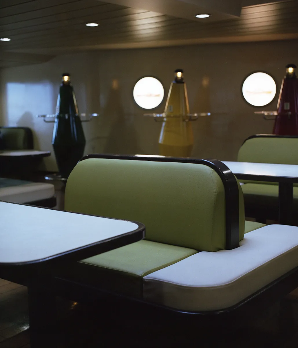 Een foto van een bank op de ferry naar Texel. Een retro look in een groene kleur.