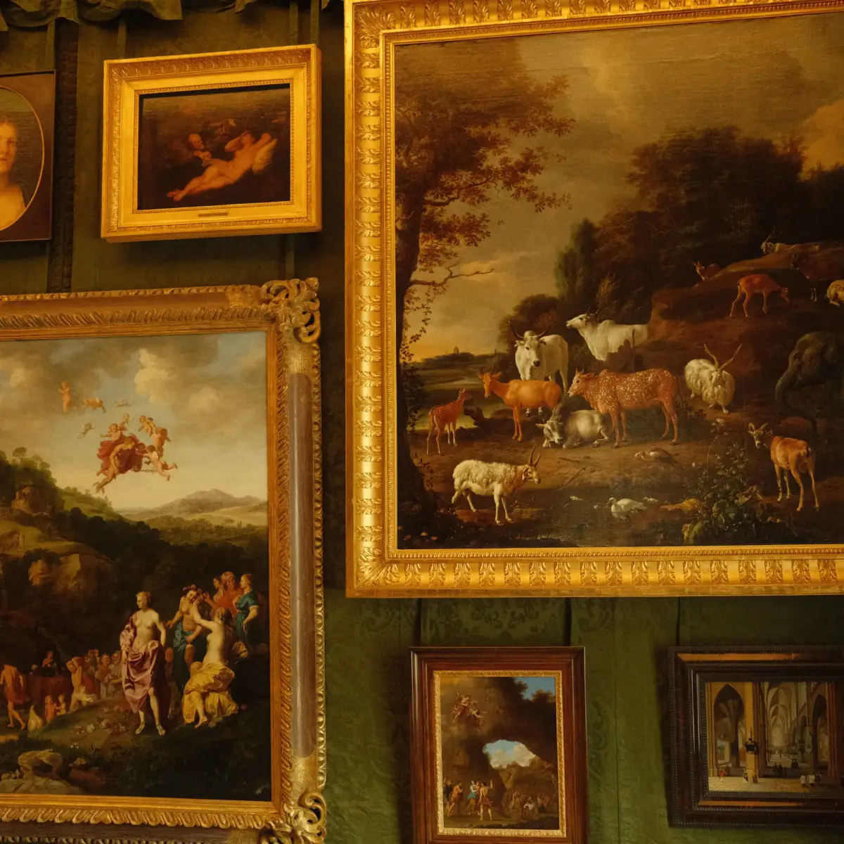 een gallerie muur in een statig huis uit de jaren 30 met schilderkunst in verschillende lijsten