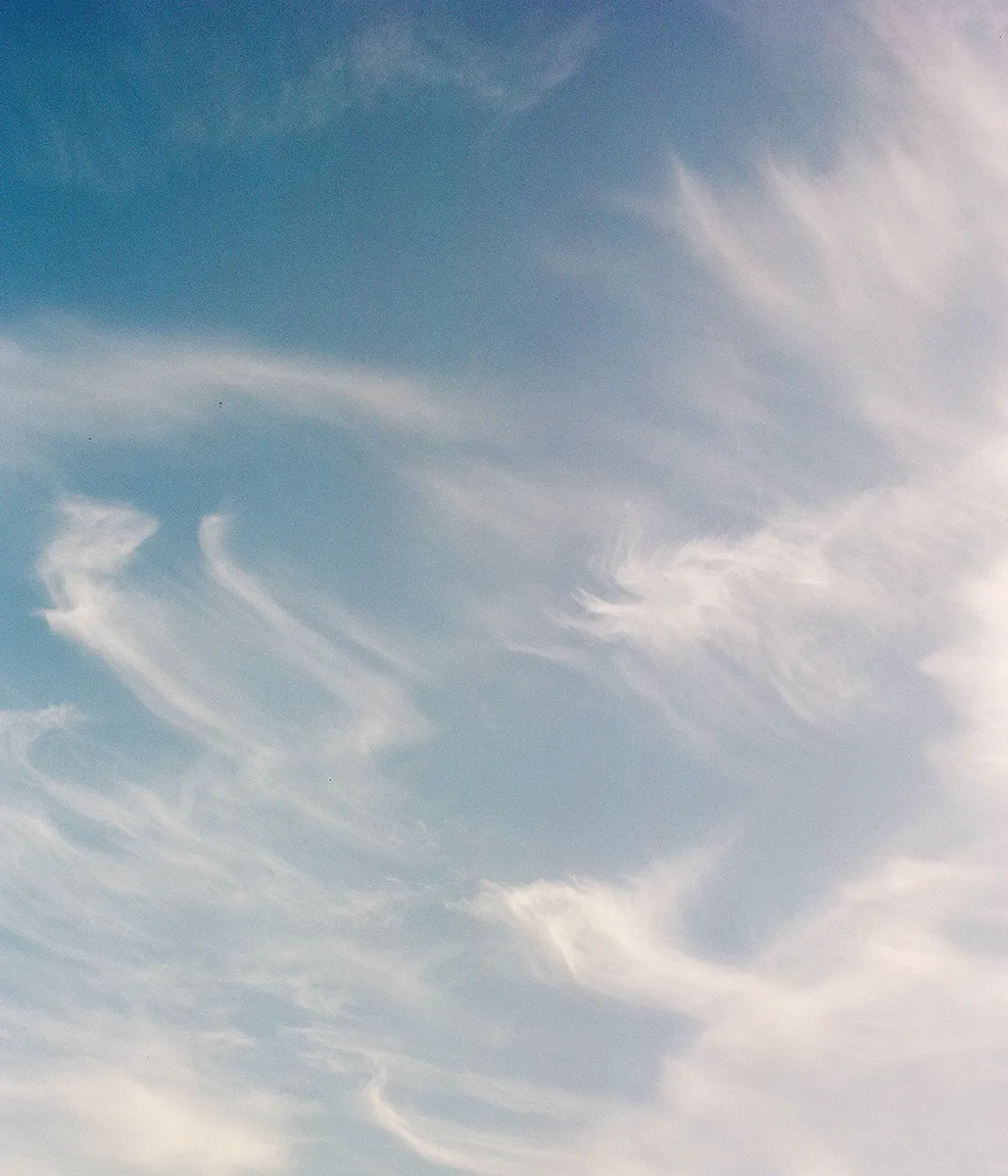 Een foto van wolken die door de harde wind enorm uitgerekt over de lucht bewegen.